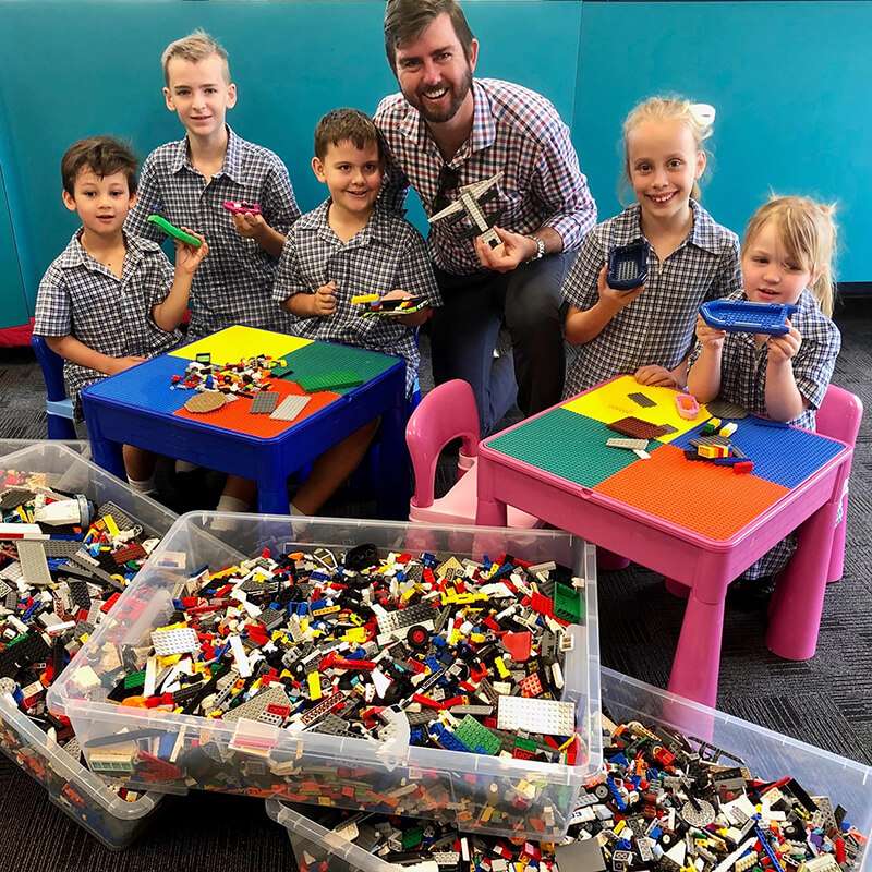 Children with their teacher assembling LEGO in school